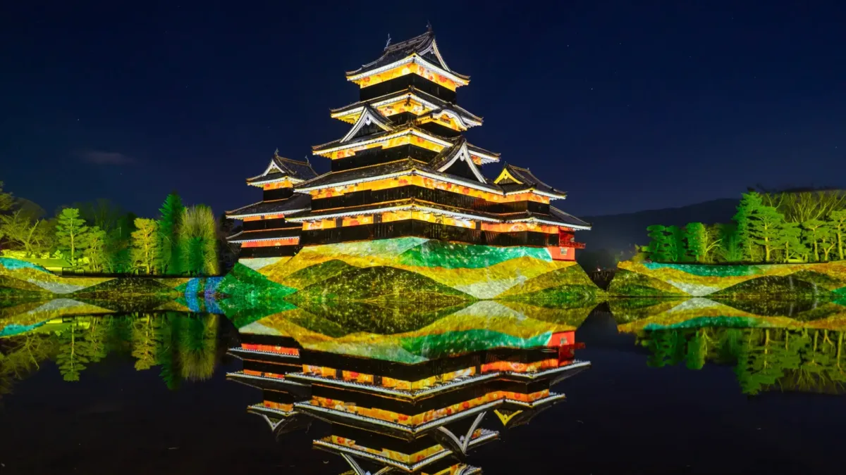 夜の松本城の美しい姿、水面反射、周囲の木々もライトアップ