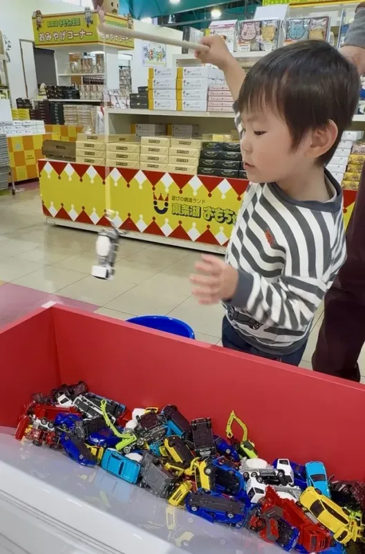 男の子がおもちゃの魚釣りゲームをしている写真